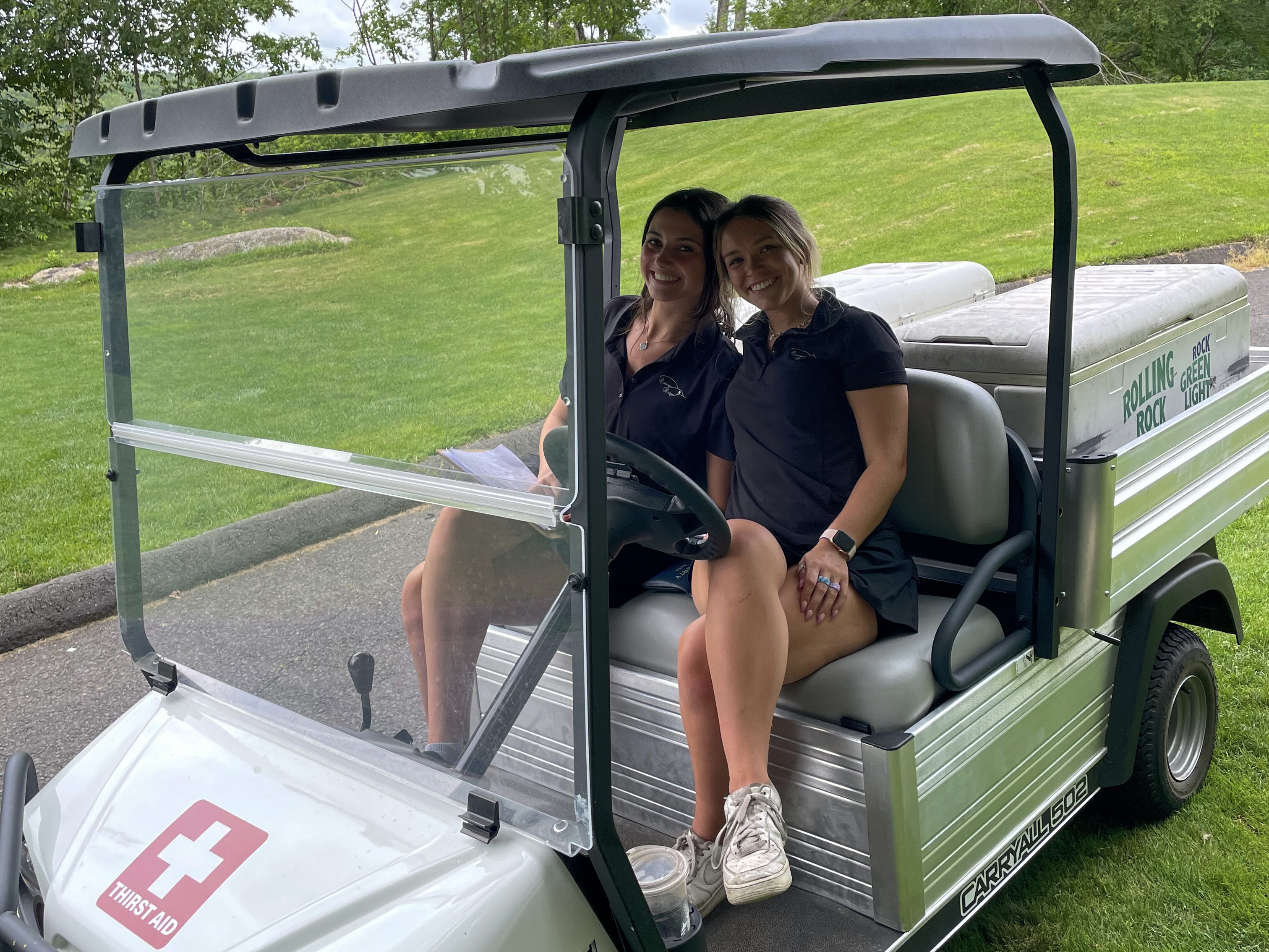 Two women sitting in a golf cart